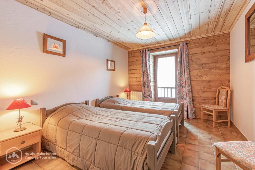 - une chambre avec 2 lits dans une chambre avec une fenêtre dans l'établissement 153 Rue des Rochers, à Lanslevillard