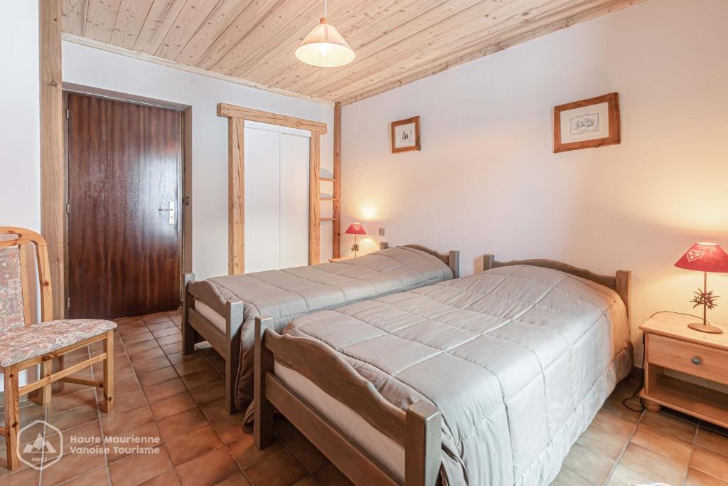 une chambre avec un grand lit dans une pièce dans l'établissement 153 Rue des Rochers, à Lanslevillard