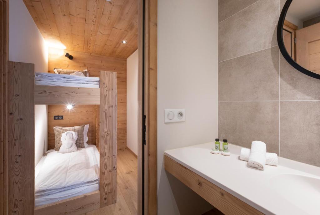 La salle de bains est pourvue de lits superposés et d'un lavabo. dans l'établissement Chalet Hôtelier LES EQUINOXES - VAL D'ISERE, à La Daille