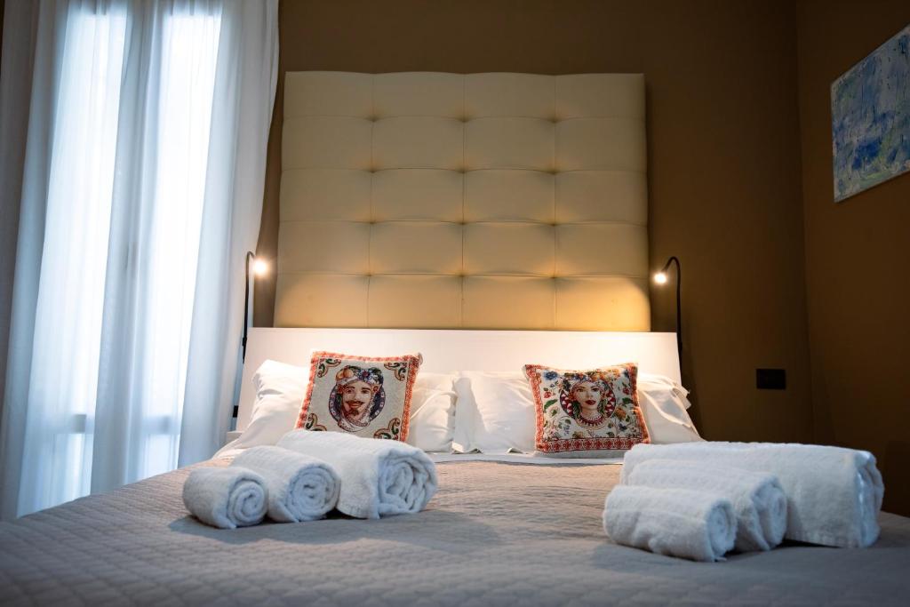 une chambre avec un grand lit avec des serviettes dessus dans l'établissement Villa Calipso, à Mondello