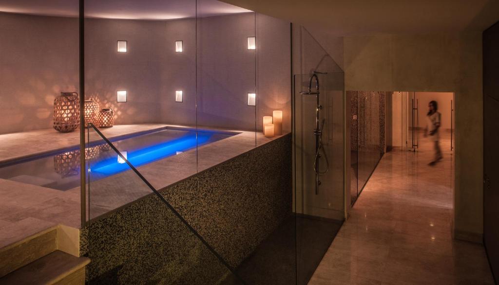 - une piscine dans une pièce où une femme se promène en arrière-plan dans l'établissement Cala Cuncheddi - VRetreats, à Murta Maria