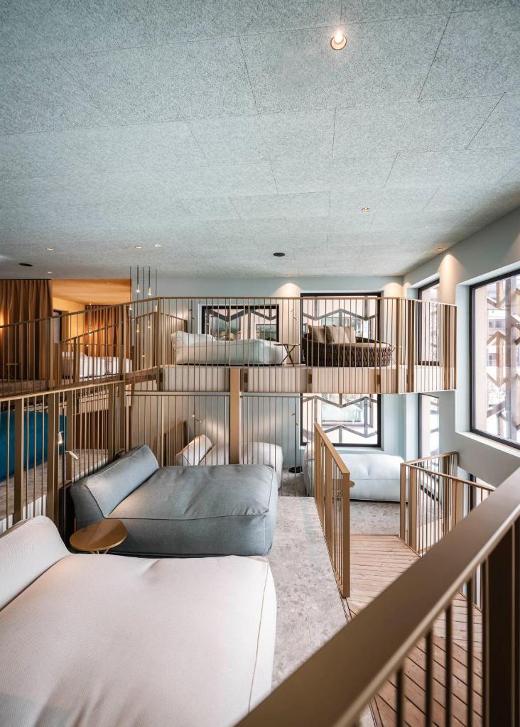 une chambre avec un canapé et un lit dans une pièce dans l'établissement Falkensteiner Family Resort Lido Superior, à Chienes