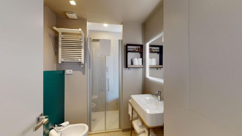 une salle de bain avec un lavabo, une douche et des toilettes dans l'établissement DIVA HOTEL LIGNANO - Adults Only, à Lignano Sabbiadoro