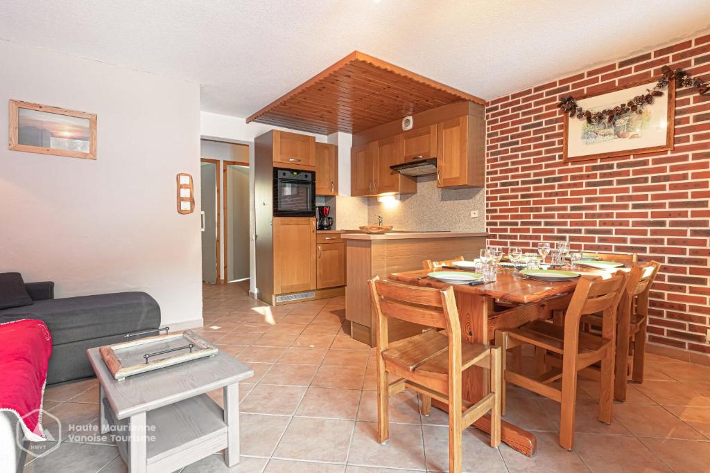 une cuisine et une salle à manger avec une table et un canapé dans l'établissement Résidence Le Pied des Pistes C6, à Lanslevillard