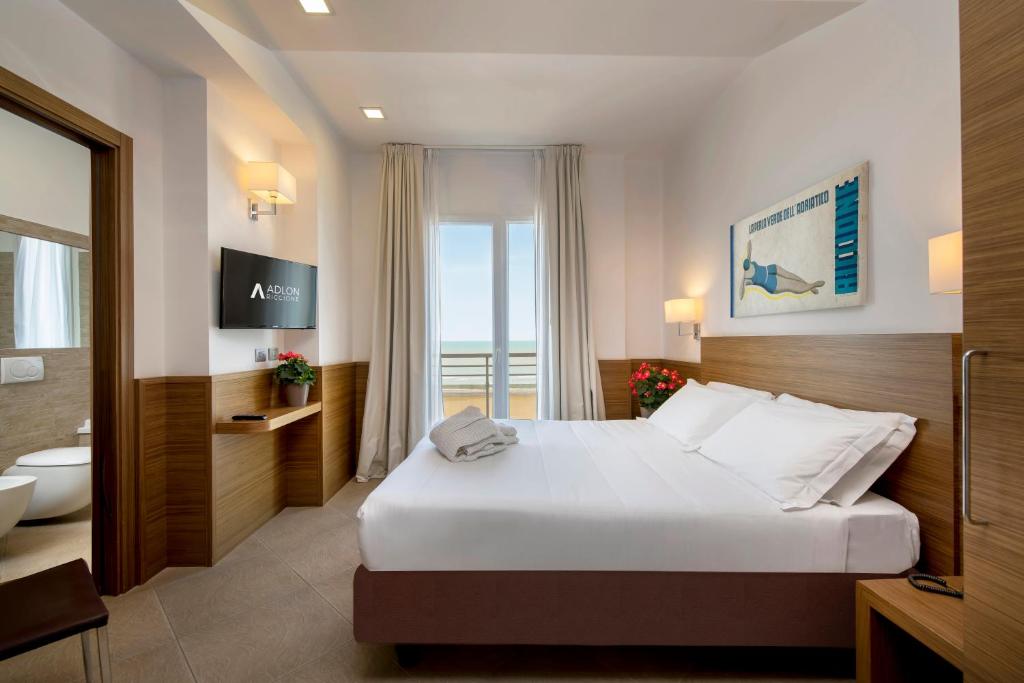 une chambre d'hôtel avec un lit et une salle de bain dans l'établissement Hotel Adlon - FRONTE MARE, à Riccione