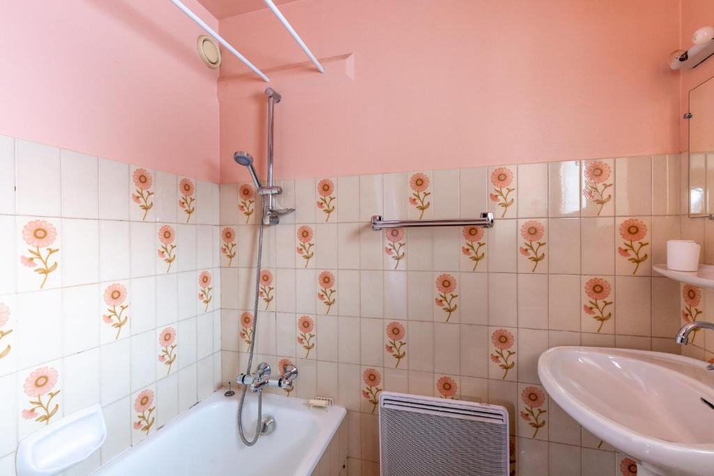 une salle de bain avec une baignoire et un lavabo dans l'établissement Apartment with terrace at the foot of the slopes, à La Clusaz