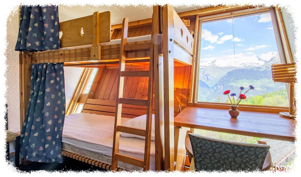 - une chambre avec des lits superposés, un bureau et une fenêtre dans l'établissement les 3 marmottes - Les Arolles, à Bourg-Saint-Maurice