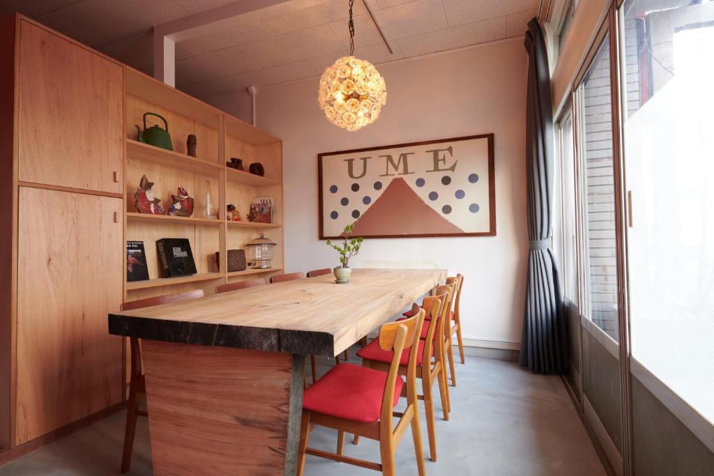 une salle à manger avec une grande table et des chaises en bois dans l'établissement Ryokan Plum, à Odawara