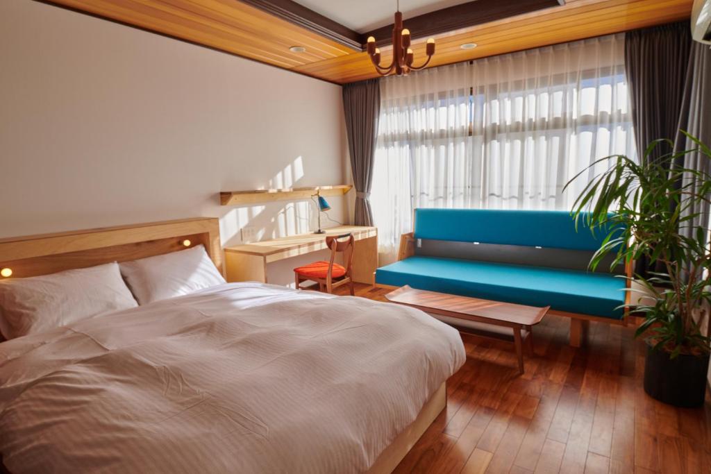 - une chambre avec un lit et un banc bleu dans l'établissement Ryokan Plum, à Odawara