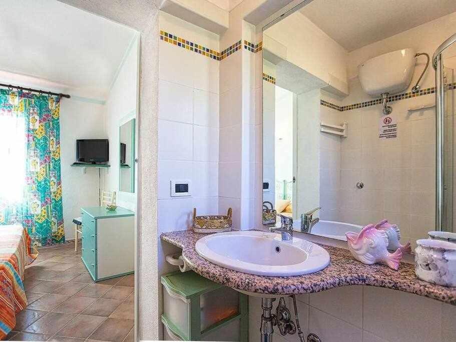 une salle de bain avec un lavabo et une chambre avec un lit dans l'établissement Costa Paradiso villa con piscina indipendente e vista mare per 6 persone, à Costa Paradiso 87 autres photos