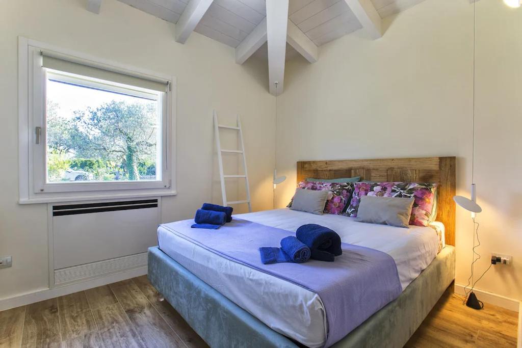 - une chambre avec un grand lit et des serviettes bleues dans l'établissement Alghero Villa Nuit Blanche con piscina Air Co WiFi vicino spiaggia, à Alghero