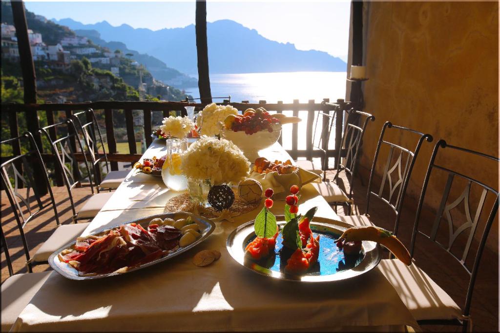 une table avec deux assiettes de nourriture sur un balcon dans l'établissement Villa Alba d'Oro - Historic luxury villa, à Amalfi