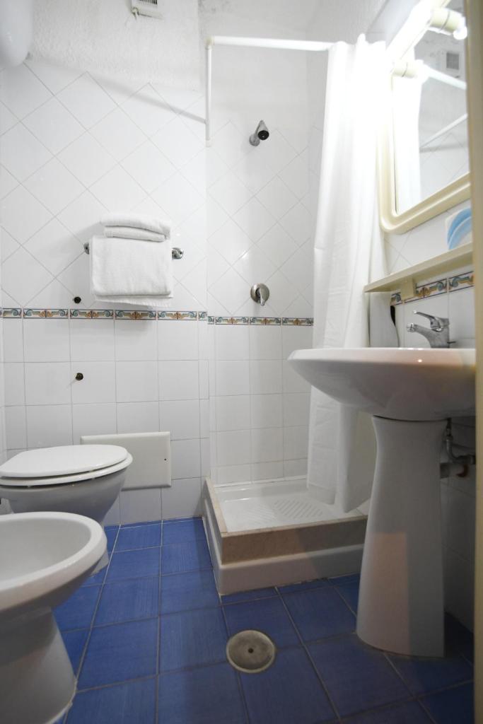 une salle de bain avec toilettes, lavabo et douche dans l'établissement International Resort, à Mondragone