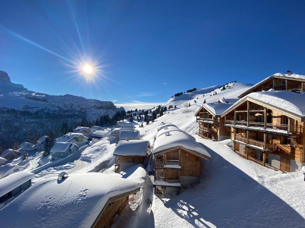 un toit enneigé d'un lodge de ski dans l'établissement Vue panoramique sur les montagnes plein Sud - T2 Skis aux pieds, Piscine & Spa, à Flaine
