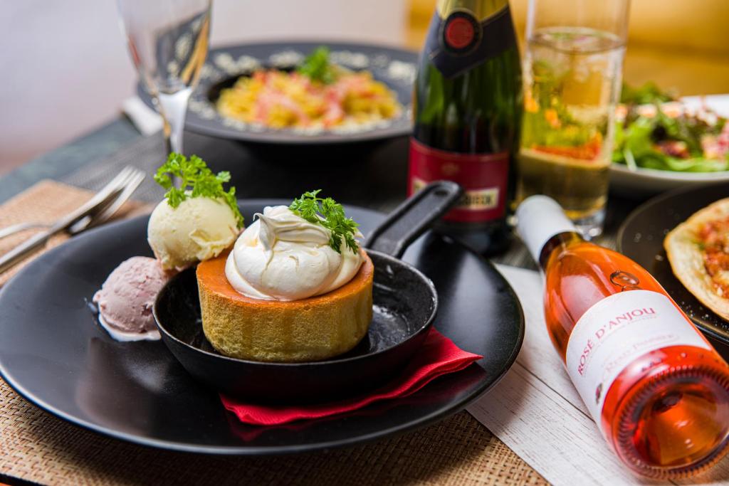 - une table avec des assiettes de nourriture et une bouteille de vin dans l'établissement ホテル リトルチャペルクリスマス 梅田, à Osaka