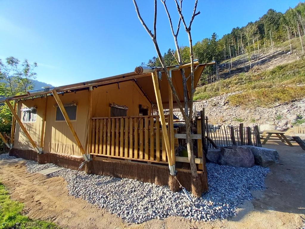 une petite cabine avec une terrasse couverte et une clôture dans l'établissement LA TENTE DU RANDONNEUR, à Rimbach-près-Masevaux