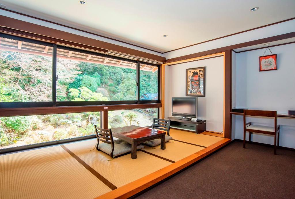 un salon avec une table et une grande fenêtre dans l'établissement Koyasan Shukubo Fumonin, à Koyasan