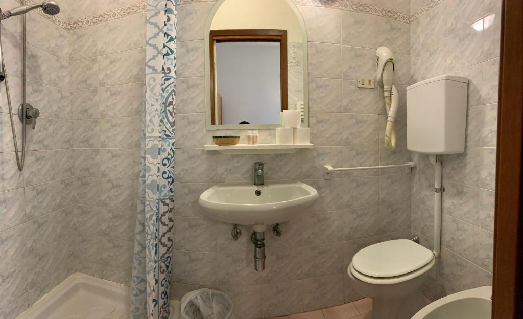une salle de bain avec un lavabo, des toilettes et un miroir dans l'établissement Hotel Marylise, à Rimini