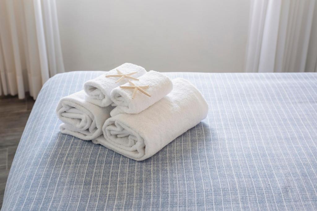 une pile de serviettes posée sur un lit dans l'établissement Hotel La Caletta, à Porto Santo Stefano