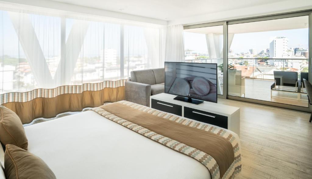 une chambre d'hôtel avec un lit et une télévision à écran plat dans l'établissement Bellini Relais, à Lignano Sabbiadoro