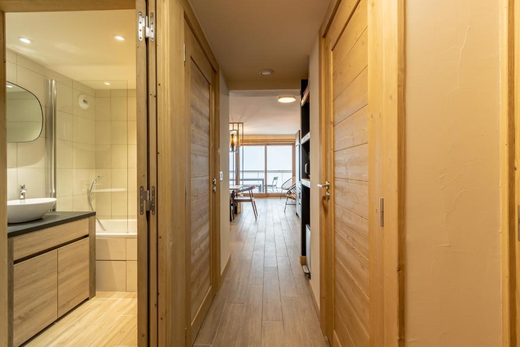 - un couloir d'une salle de bains pourvue d'un lavabo et d'un miroir dans l'établissement Les ARCS 1600 - SKI AUX PIEDS - MAGNIFIQUE DUPLEX 12 PERSONNES, à Bourg-Saint-Maurice