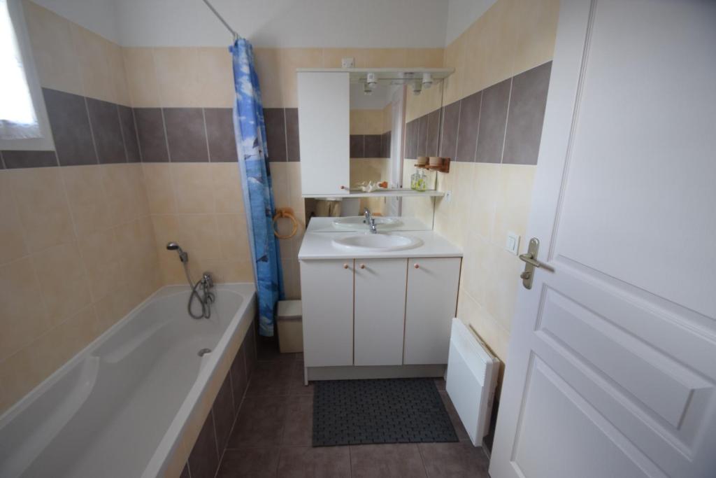 une salle de bain avec une baignoire et un lavabo et une baignoire dans l'établissement T3 coquet et lumineux aux pieds des pistes, à Ancelle