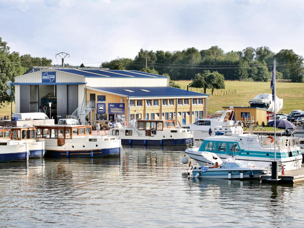 un port de plaisance avec des bateaux amarrés devant un bâtiment dans l'établissement Kuhnle-Tours Niderviller, à Niderviller