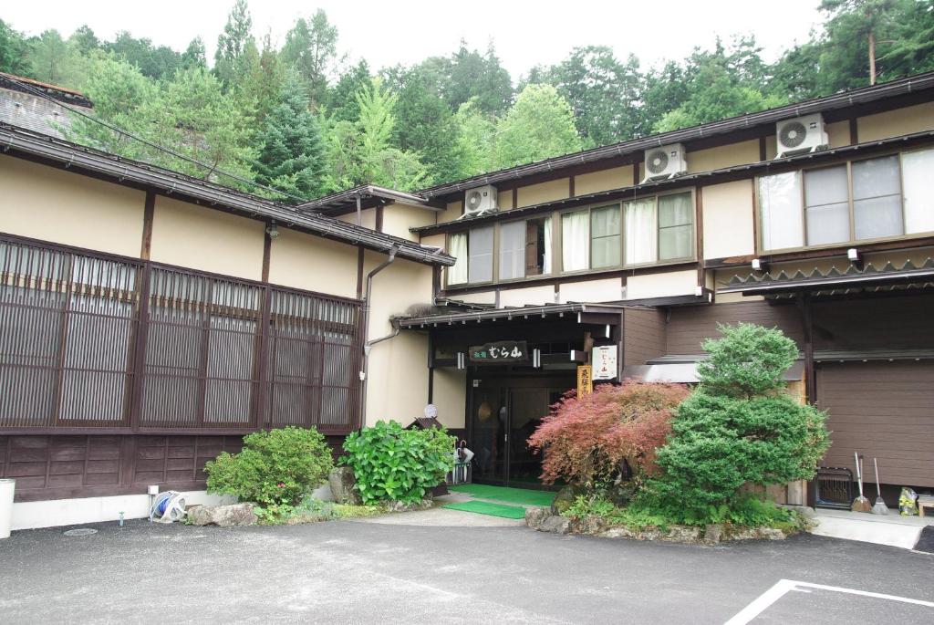 un bâtiment avec un parking devant dans l'établissement Ryokan Murayama, à Takayama