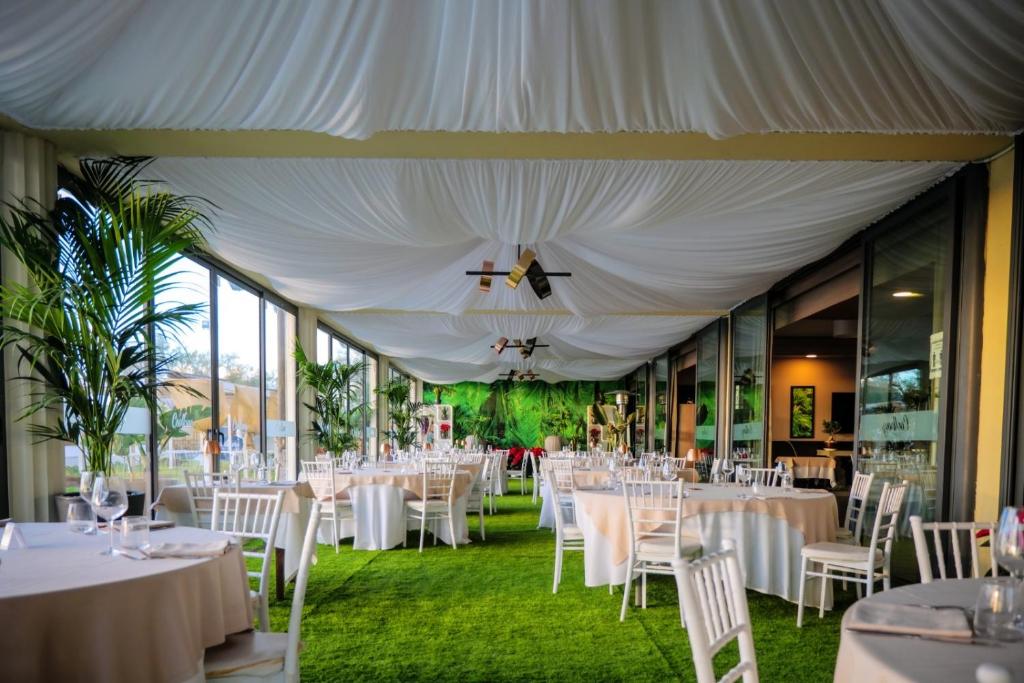 une pièce avec des tables et des chaises recouvertes de nappes blanches dans l'établissement MOOD Sea Stage, à Castiglione