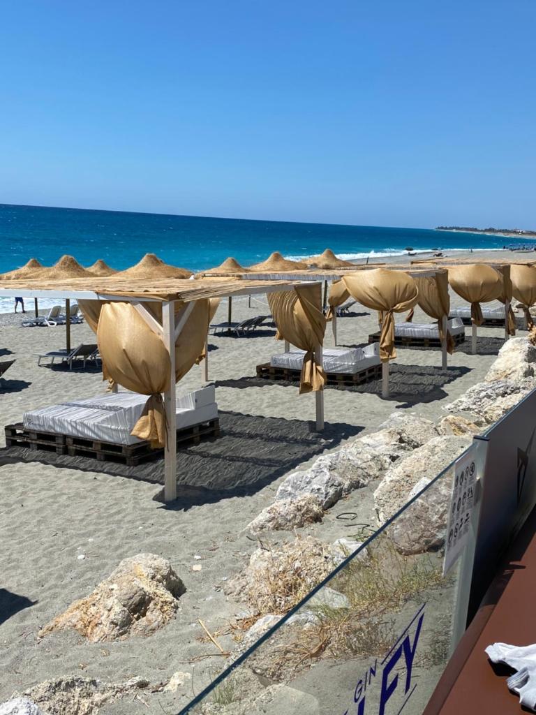 une plage avec des chaises et des parasols et l'océan dans l'établissement MOOD Sea Stage, à Castiglione