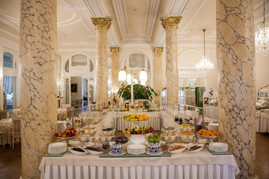 une table avec de la nourriture dans une pièce avec des colonnes dans l'établissement Residenza Parco Fellini, à Rimini
