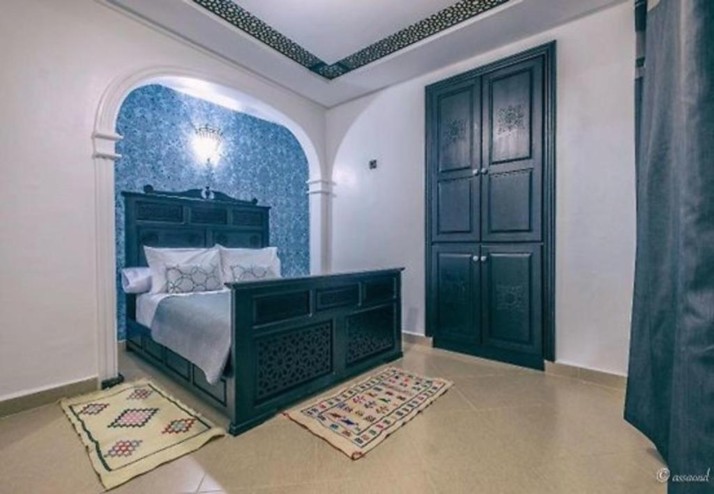 - une chambre avec un lit et une grande porte dans l'établissement HOTEL PEDRO, à Chefchaouen