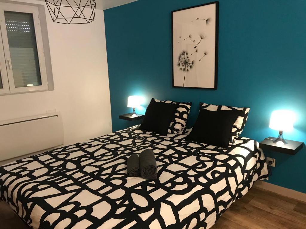 une chambre avec un lit noir et blanc avec deux lampes dans l'établissement PAUSE NATURE SORBAIS Gite de groupe avec Piscine, Spas, Sauna avec 8 chambres et 8 salles de bain, grande cuisine et grande salle de vie, à Sorbais