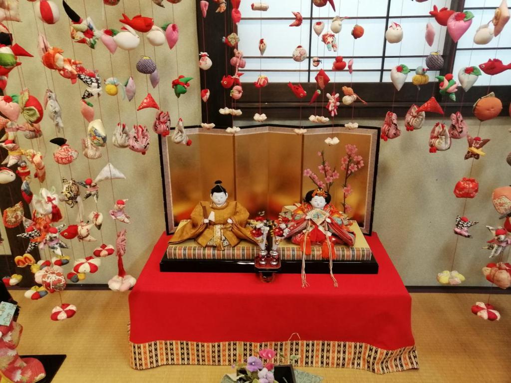 Cette chambre comprend une table avec deux poupées. dans l'établissement Hamayuu, à Higashiizu
