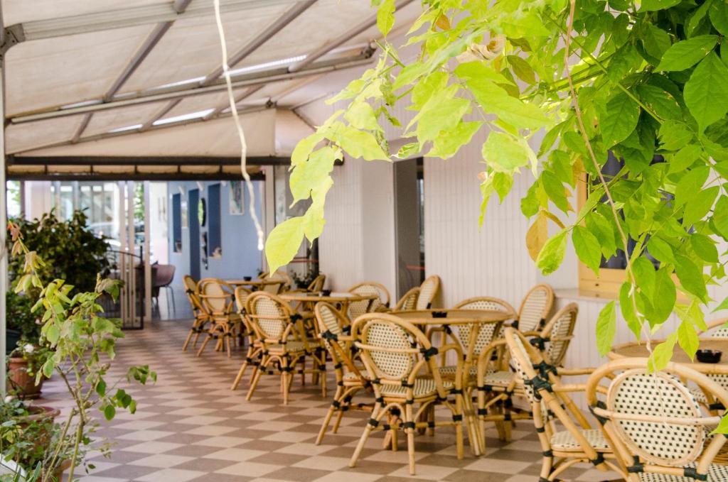 une rangée de tables et de chaises dans un restaurant dans l'établissement Hotel Stella Alpina, à Rimini