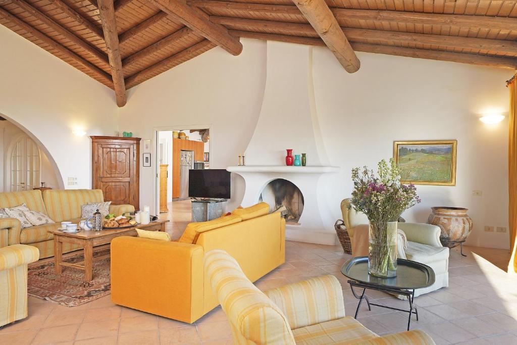 Elle comprend un salon doté d'un mobilier jaune et d'une cheminée. dans l'établissement Villa Madeleine, à Padenghe sul Garda