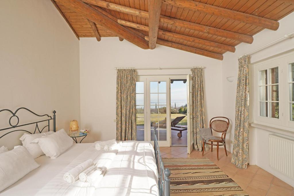 une chambre avec un grand lit et un balcon dans l'établissement Villa Madeleine, à Padenghe sul Garda 39 autres photos