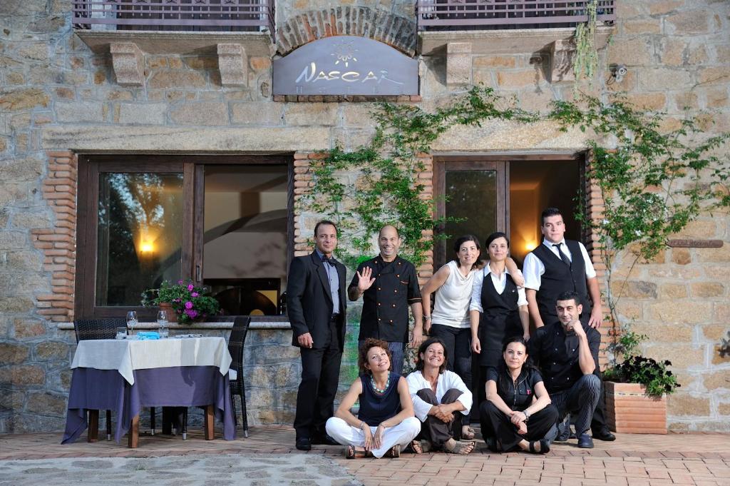 un groupe de personnes posant une photo devant un bâtiment dans l'établissement Nascar Hotel, à Santa Maria Navarrese