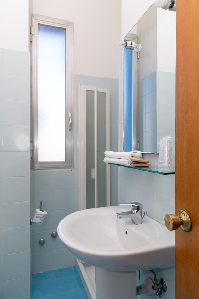 une salle de bain avec un lavabo blanc et un miroir dans l'établissement Hotel Royal, à Giulianova