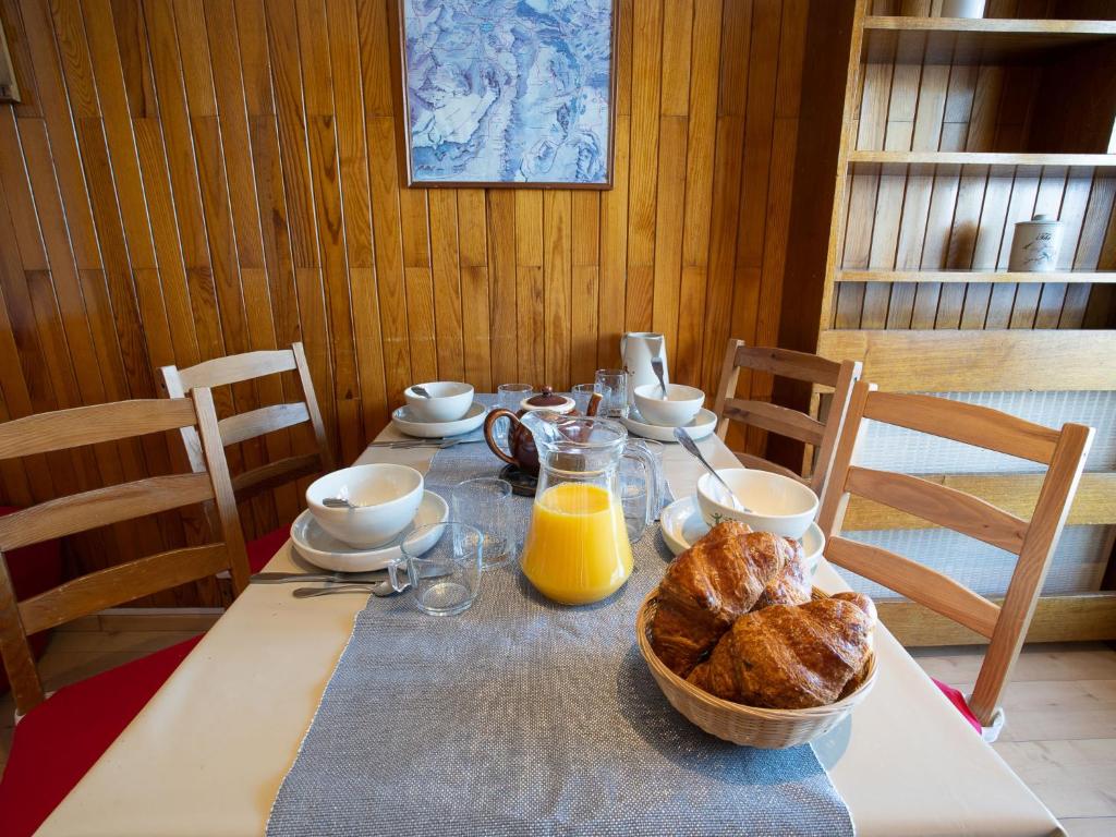 une table avec une corbeille de pain et du jus d'orange dans l'établissement Studio Le Curling B - Val Claret-36 by Interhome, à Tignes