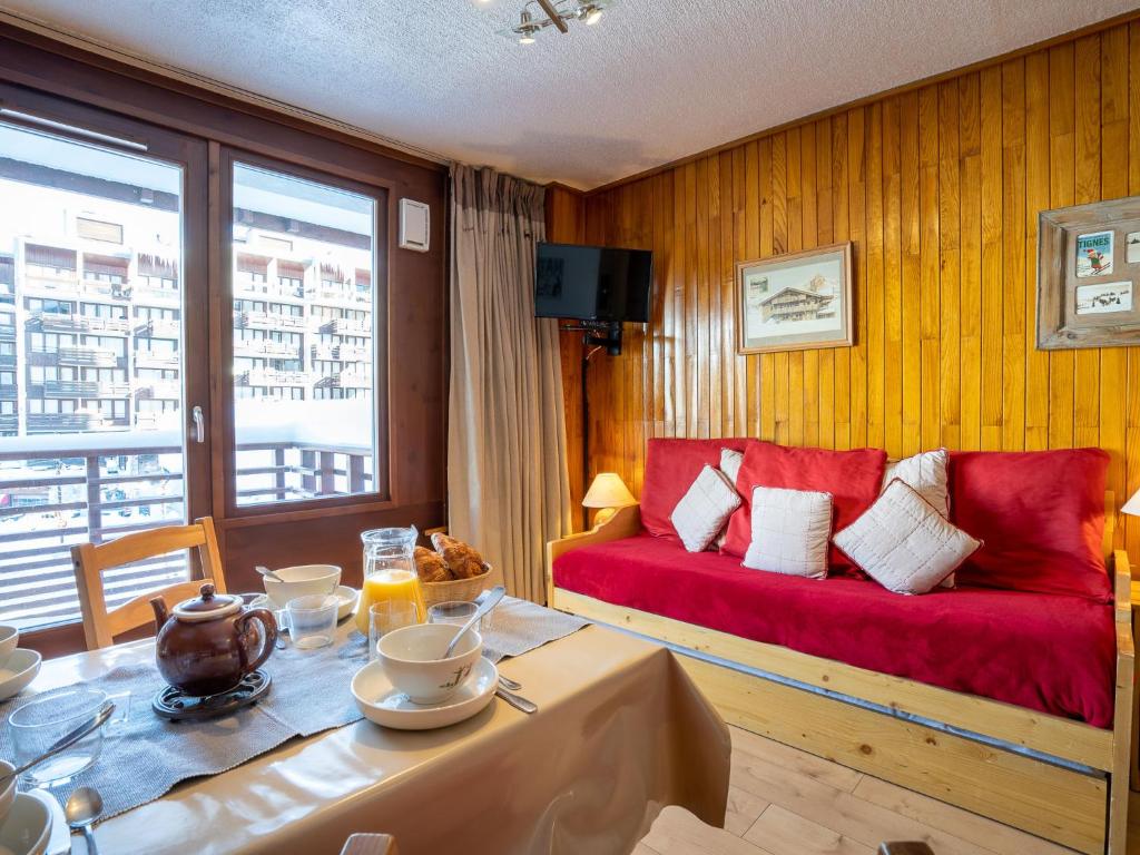 un salon avec un canapé rouge et une table dans l'établissement Studio Le Curling B - Val Claret-36 by Interhome, à Tignes