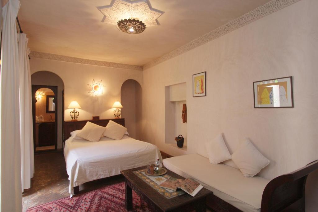 une chambre d'hôtel avec deux lits et un canapé dans l'établissement Riad Massiba, à Marrakech