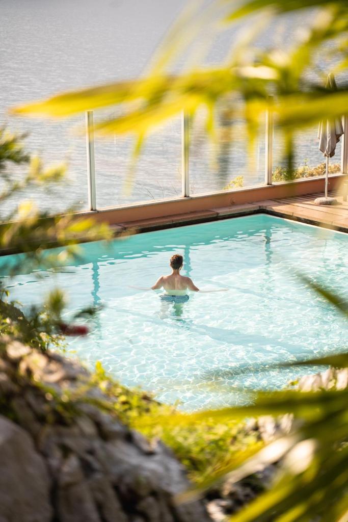 un homme nage dans une piscine dans l'établissement Villa Tempesta, à Nago-Torbole