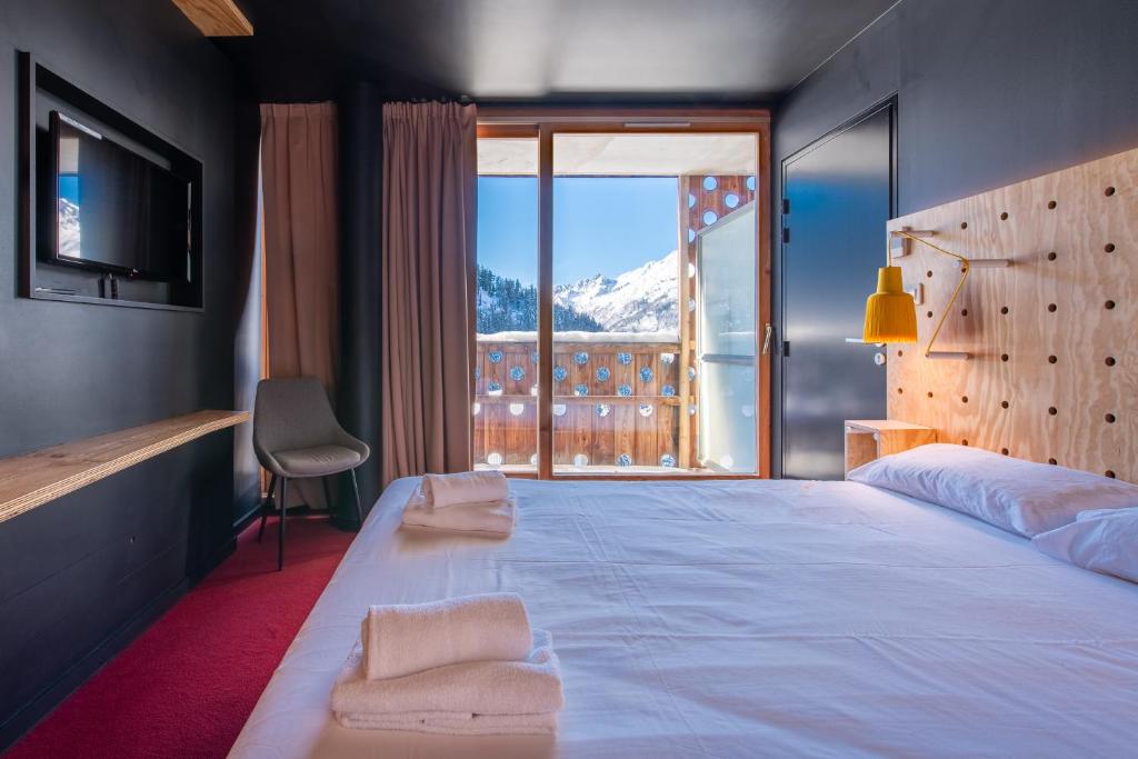 une chambre avec un grand lit avec une grande fenêtre dans l'établissement SUNWEB - Timberlodge, à Oz