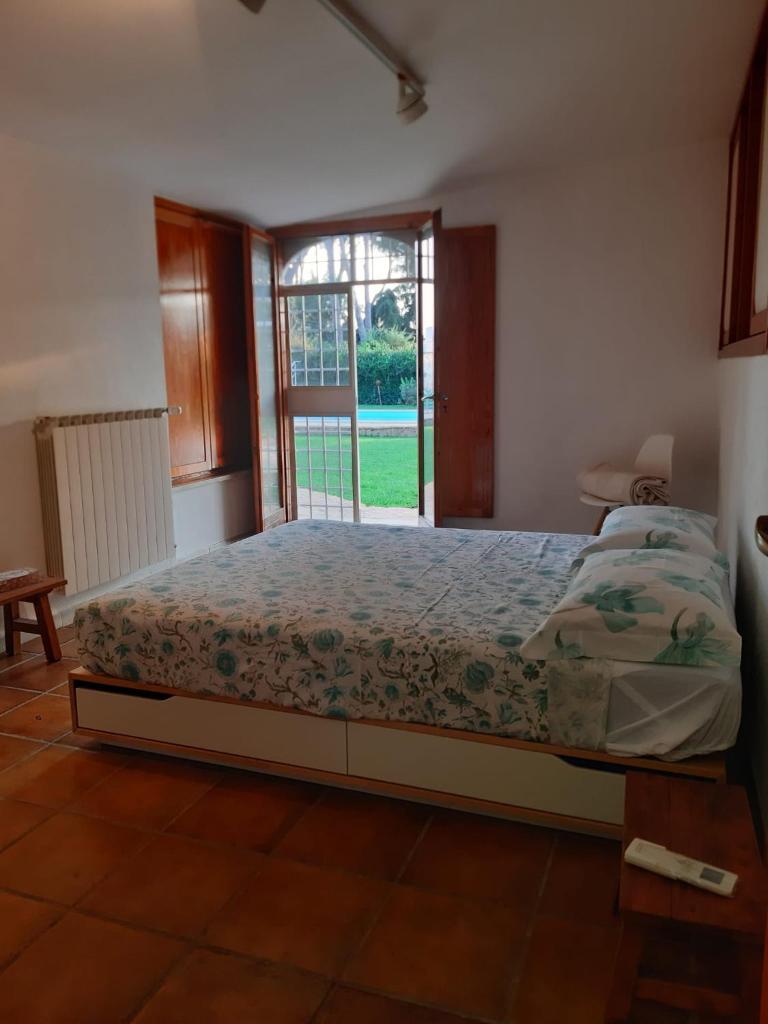 une chambre avec un lit et une grande fenêtre dans l'établissement Villa con piscina Circeo - Sabaudia, à Borgo Montenero