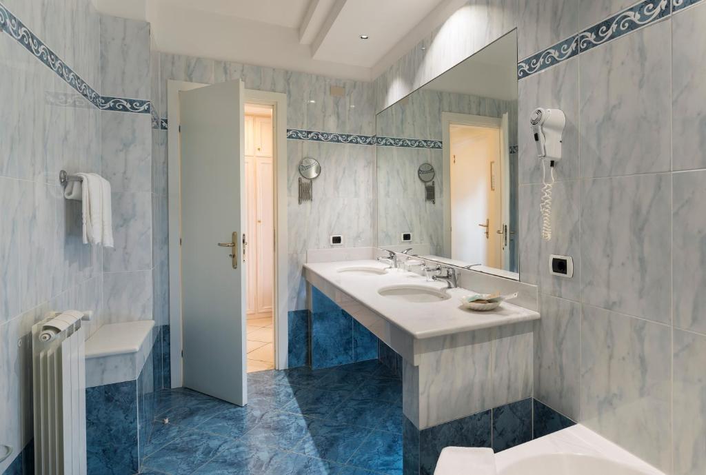 une salle de bain avec un lavabo et un miroir dans l'établissement Sant Alphio Garden Hotel & SPA, à Giardini Naxos