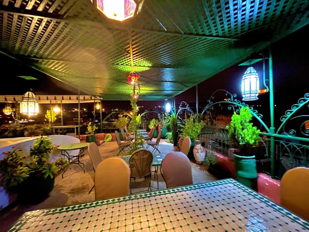 un restaurant avec une table, des chaises et des lumières dans l'établissement Riad Dar Guennoun, à Fès