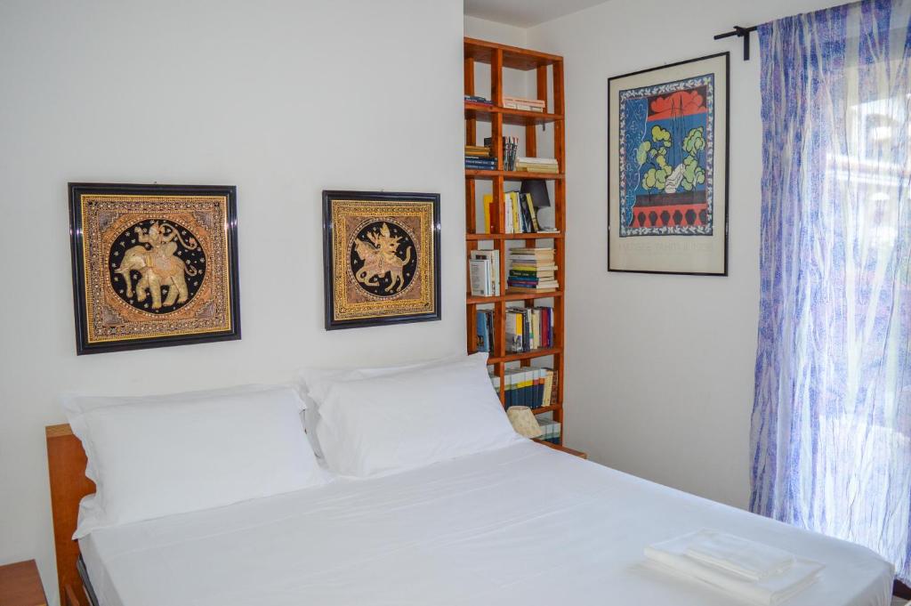 une chambre avec un lit blanc avec trois tableaux au mur dans l'établissement Homiday - Residence Micaene, à Pineto 88 autres photos