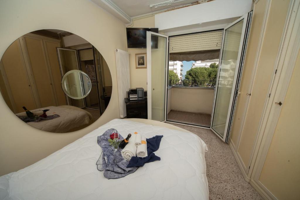 - une chambre avec un lit et un miroir rond dans l'établissement Hotel Cristina Hospitality Centrale, à Riccione