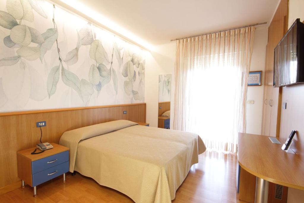 - une chambre avec un lit et une grande peinture murale dans l'établissement Hotel Toledo, à Lido di Jesolo